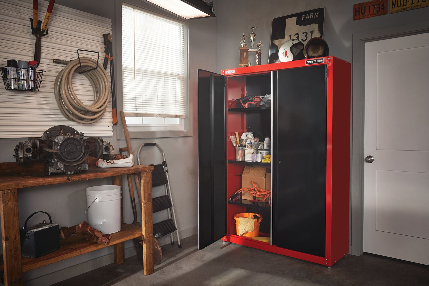 2000 SERIES 48 inch Wide Free Standing Tall Garage Storage Cabinet containing tools and other stuff with one door open placed in storage room.